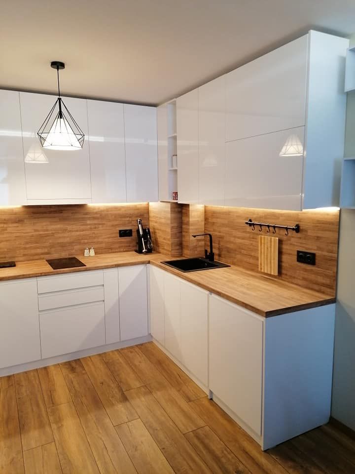 Cocina blanca con encimera y revestimiento de madera realizada por SC Interior